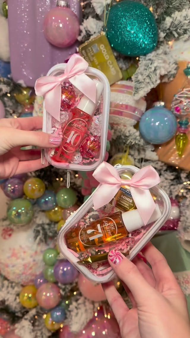 Small white gift tins with pink ribbons containing beauty products and candies.