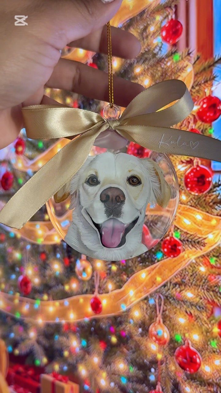 Circular Christmas ornament with a golden retriever portrait hanging on a lit tree