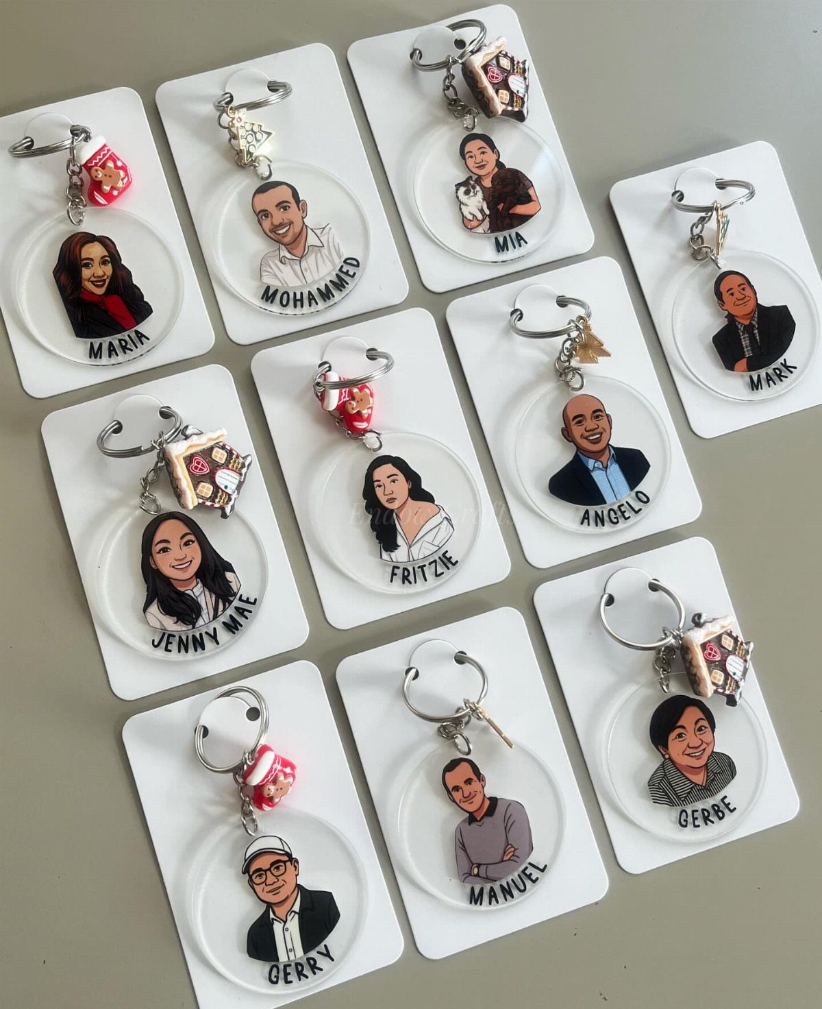 Custom acrylic keychains featuring cartoon portraits and names of different people on cards.