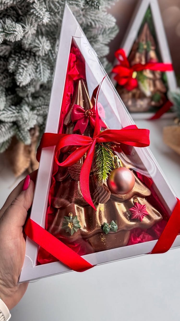Chocolate Christmas tree treat in a triangular gift box with red ribbons.