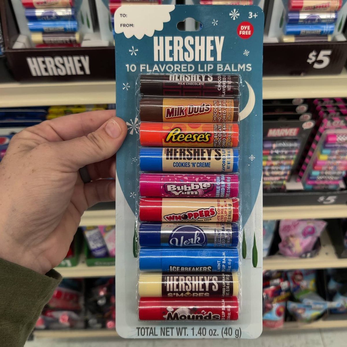 Hershey's flavored lip balm variety pack held by a hand in a store.