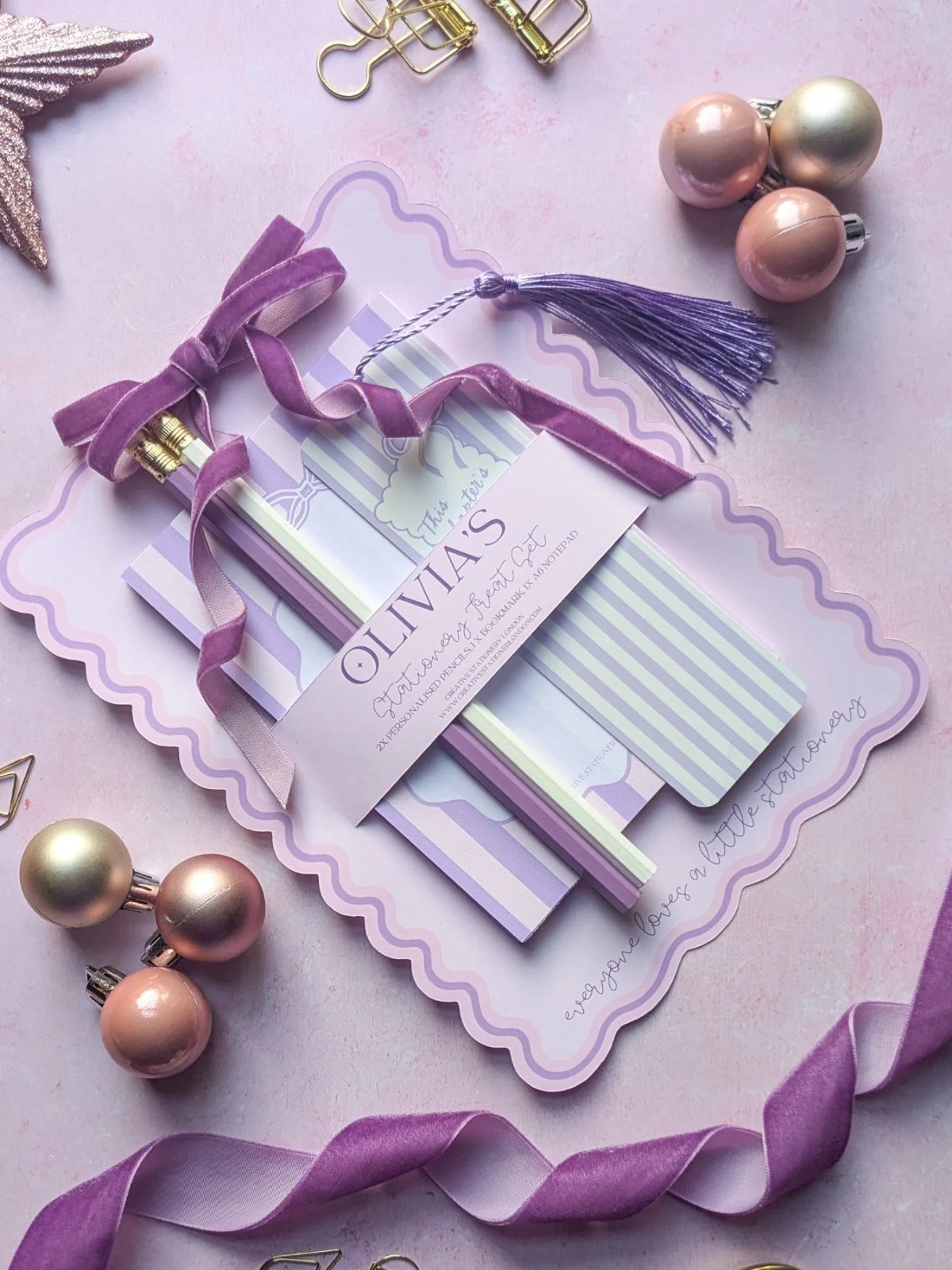 Personalized stationery set with pencils and a purple tassel bookmark on purple background