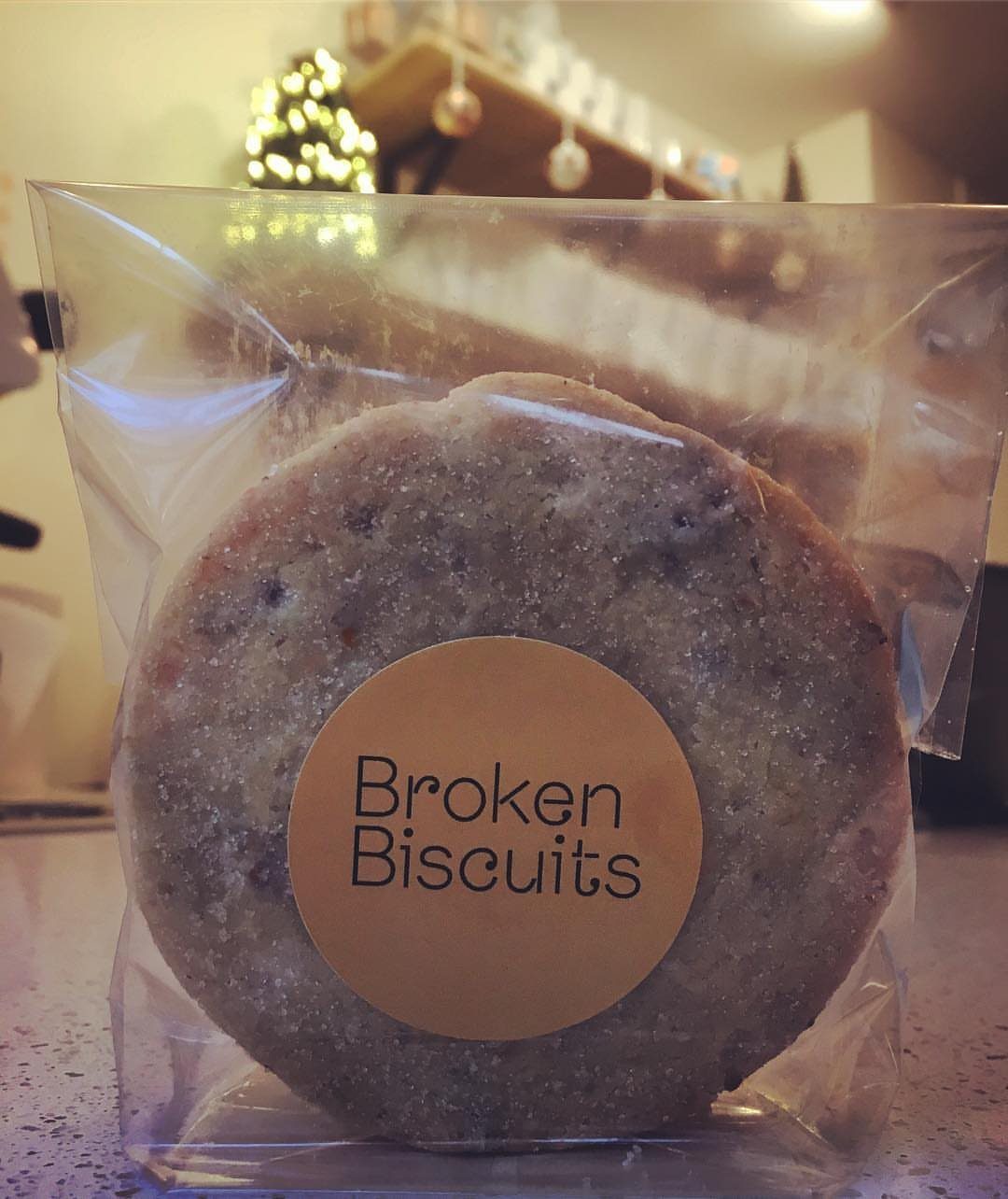 Sugar-coated biscuit in a clear plastic bag with a Broken Biscuits label