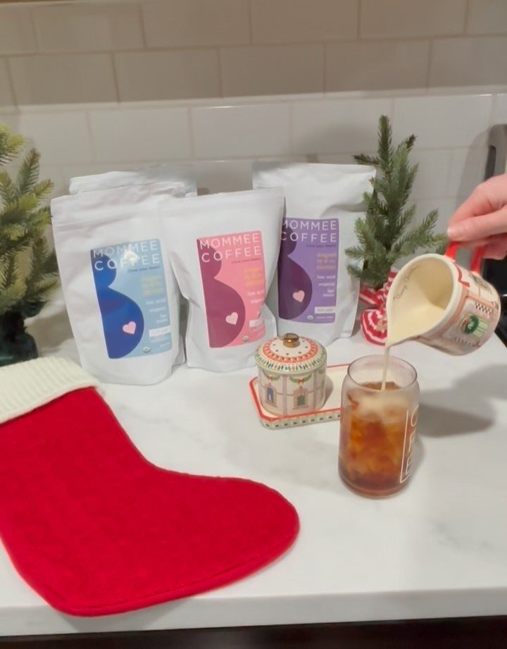 Coffee bags and a red Christmas stocking on a white marble kitchen counter.