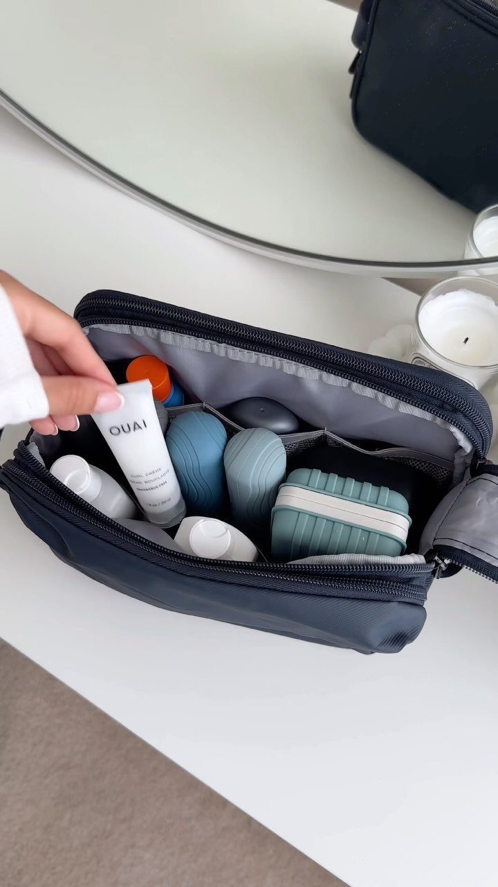 Travel size toiletries in a blue zippered bag on a white surface.