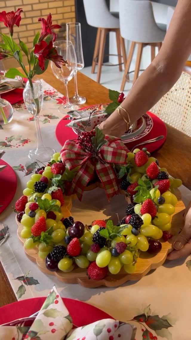 Fruit wreath centerpiece with grapes and berries on a festive Christmas dinner table