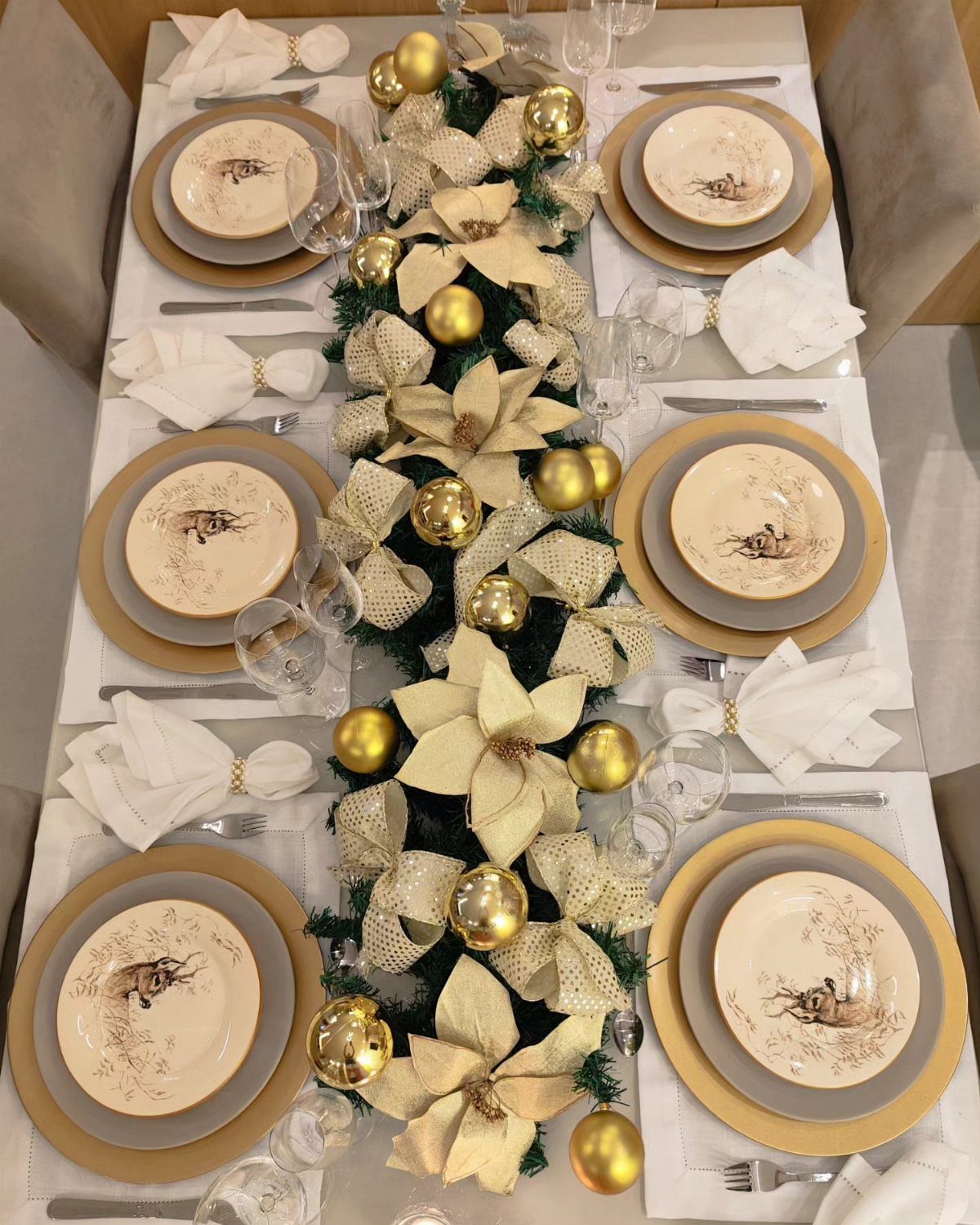 Gold-hued Christmas table setting with gold chargers, cream plates, and festive gold centerpieces.