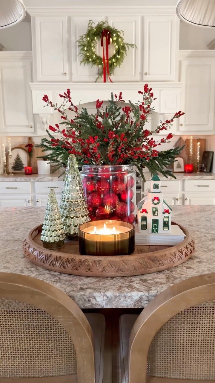 Christmas table decorations featuring red ornaments in a jar and small glittery trees.