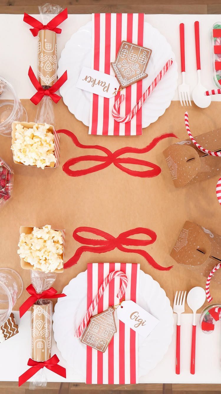 Christmas table setting with candy canes, gingerbread cookies, and red striped napkins.