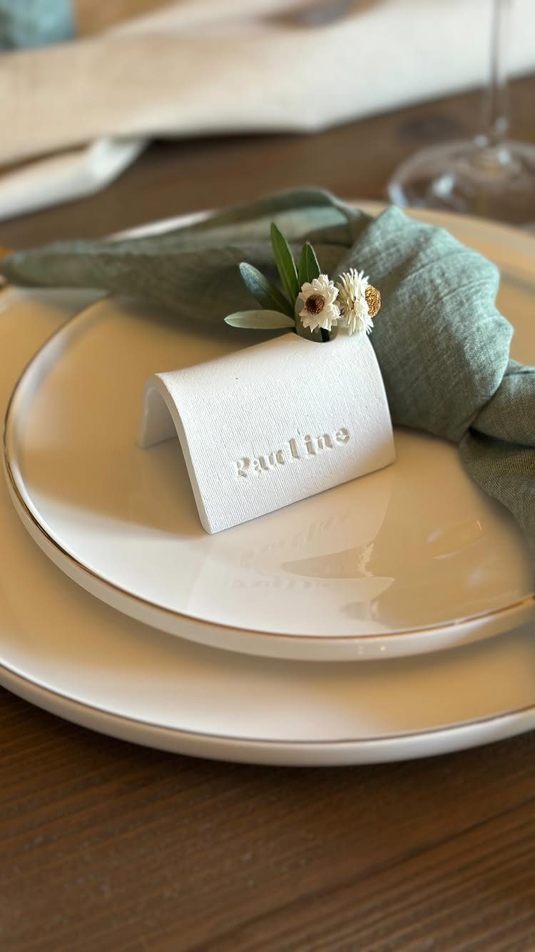 White place card with name Pauline on a plate with green linen napkin