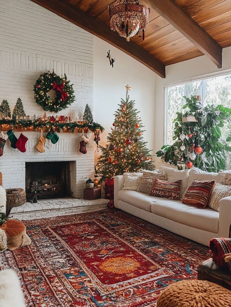 Christmas decorated living room with a white fireplace, lit tree, and red rug.
