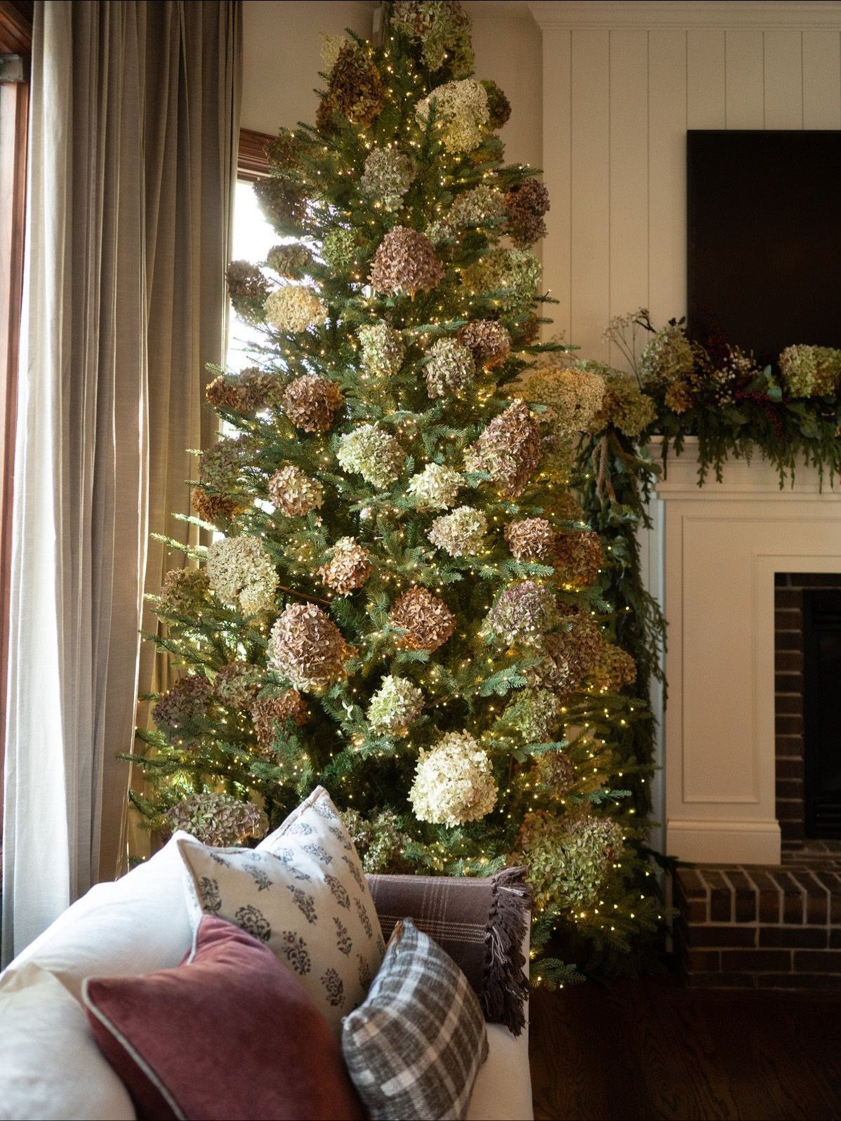 Christmas tree decorated with large cream and brown floral blooms and warm lights