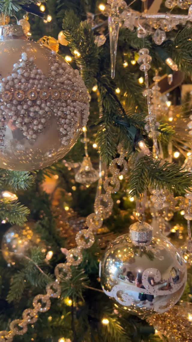 Decorated Christmas tree with pearl baubles, silver ornaments, and clear icicle decorations.