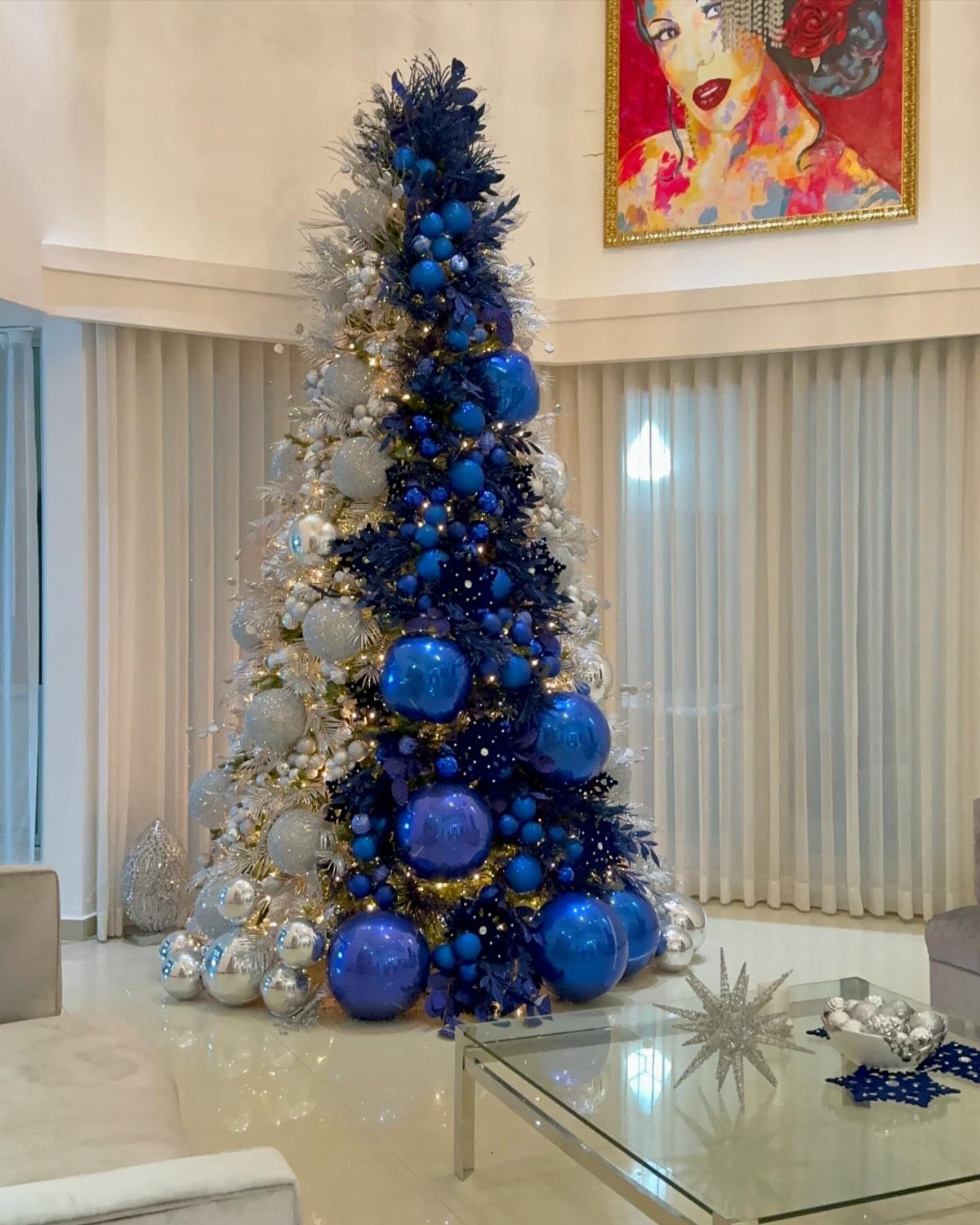 Christmas tree with a blue and silver ombré gradient of metallic ornaments.