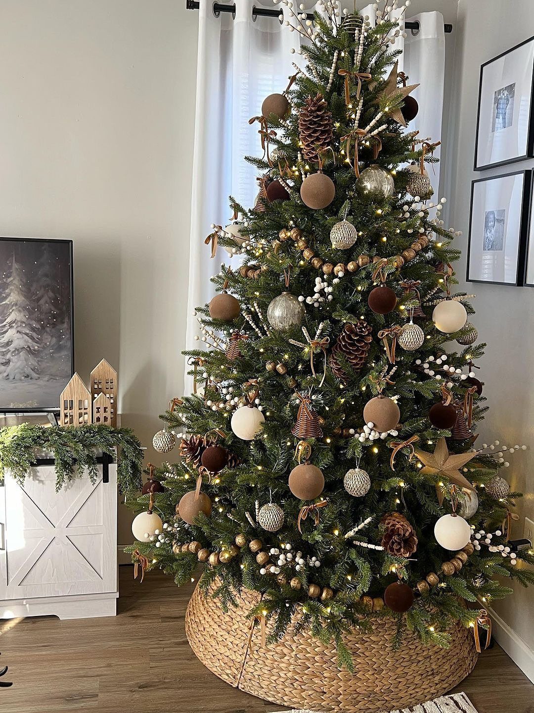 Decorated Christmas tree with neutral ornaments in a woven wicker basket base.