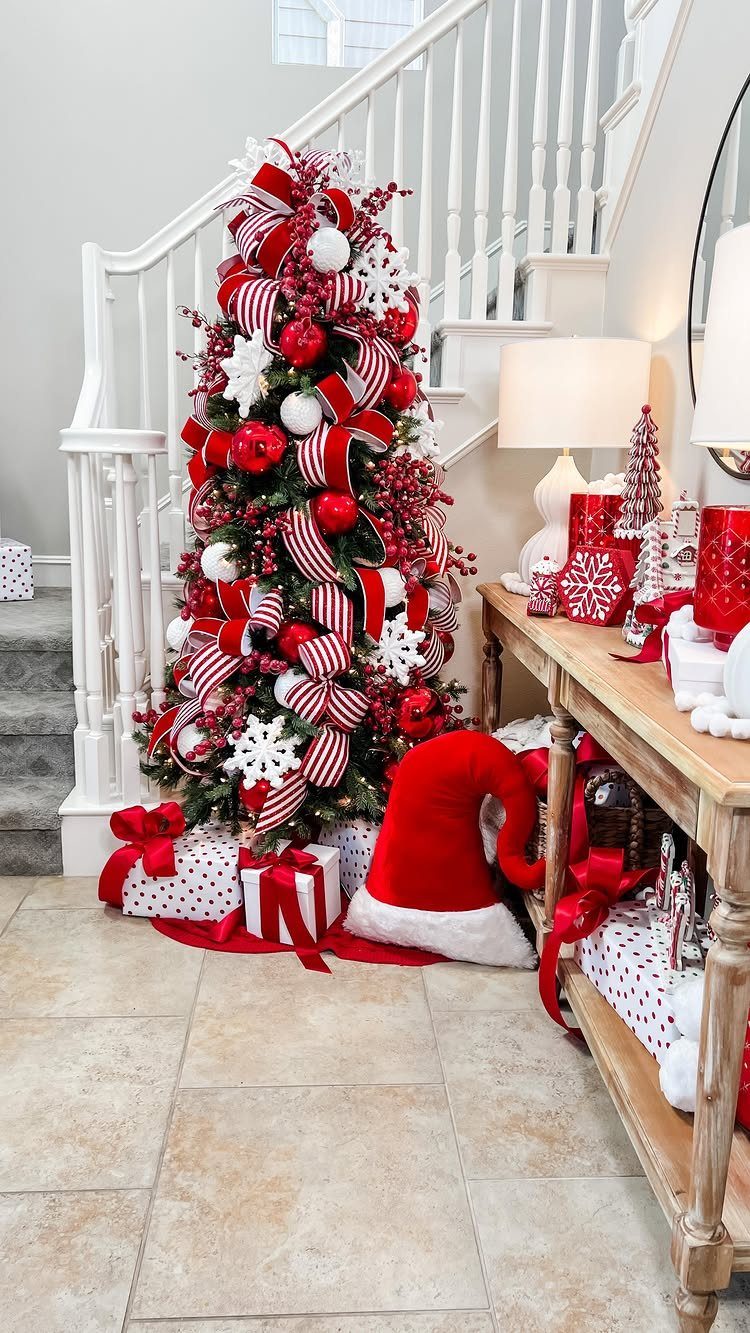Christmas tree decorated with twisted red and white striped ribbons and red ornaments.
