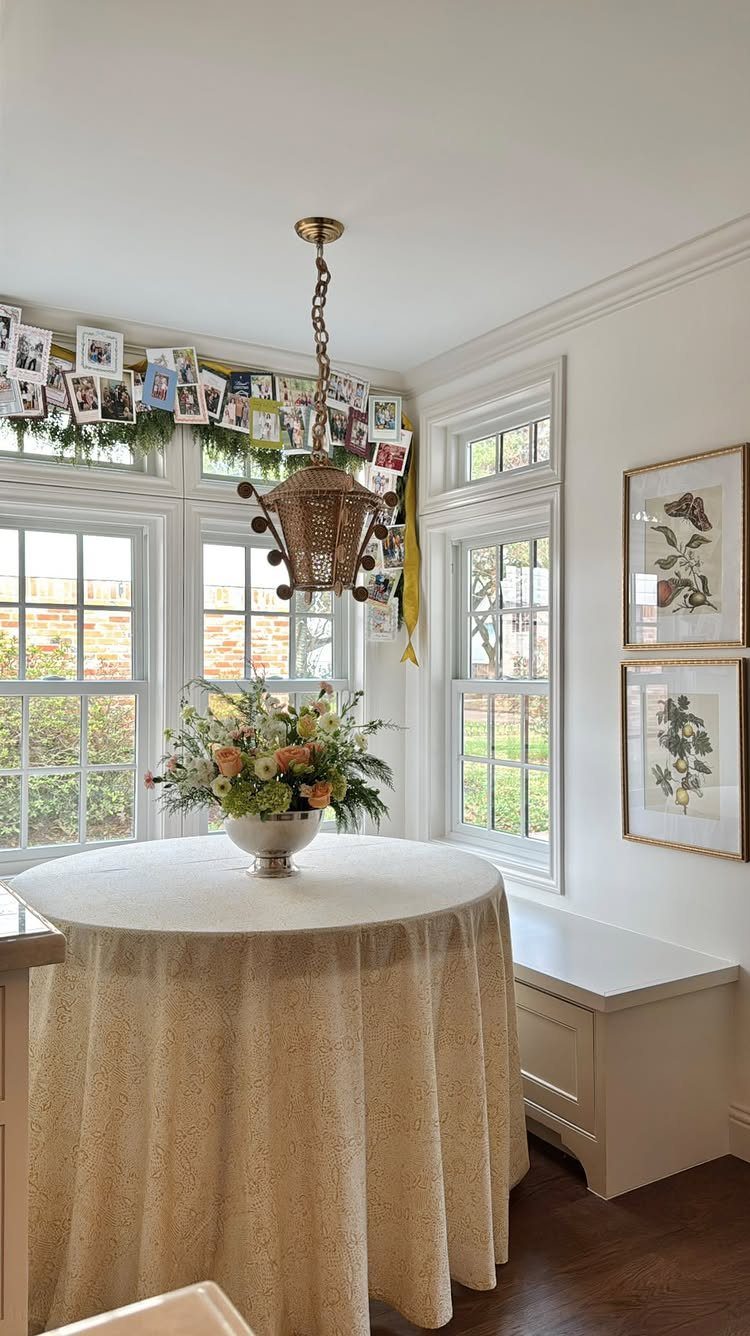 Christmas card garland with photos clipped to greenery above white window frames