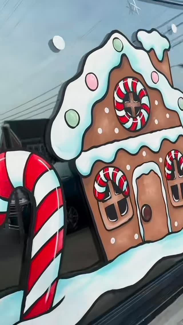 Gingerbread house and candy cane painted on a glass window for Christmas.