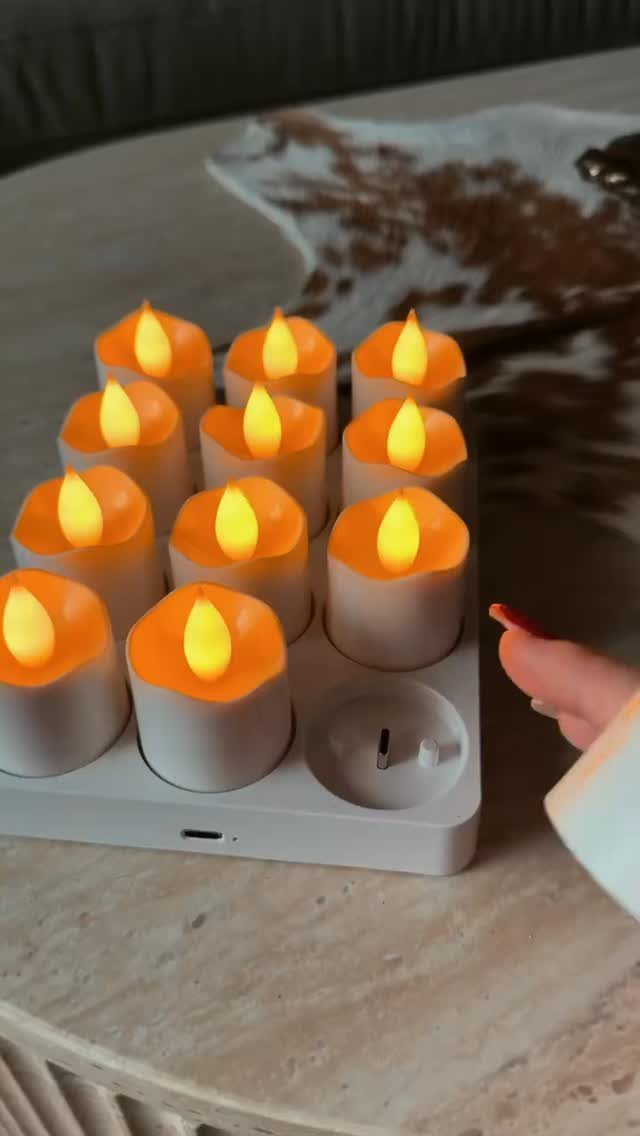 Twelve white flameless LED candles glowing orange on a white electronic base.