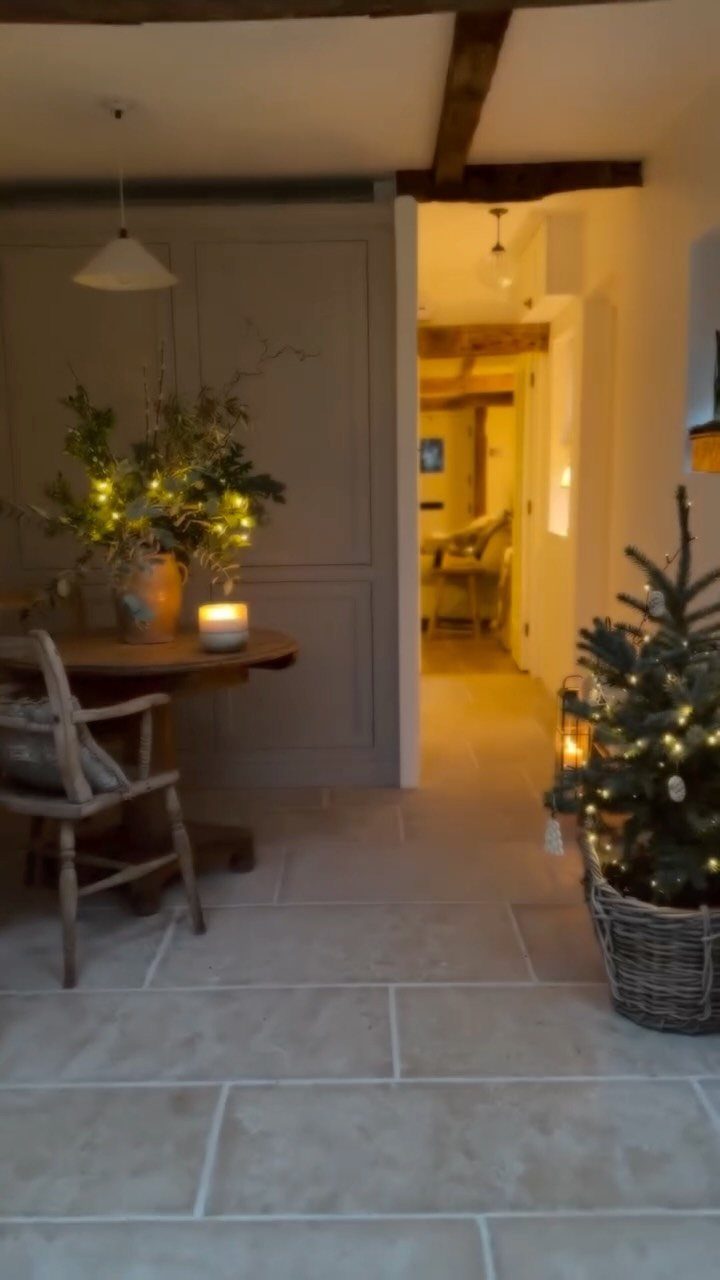 Small Christmas tree with lights in a wicker basket in a rustic room.