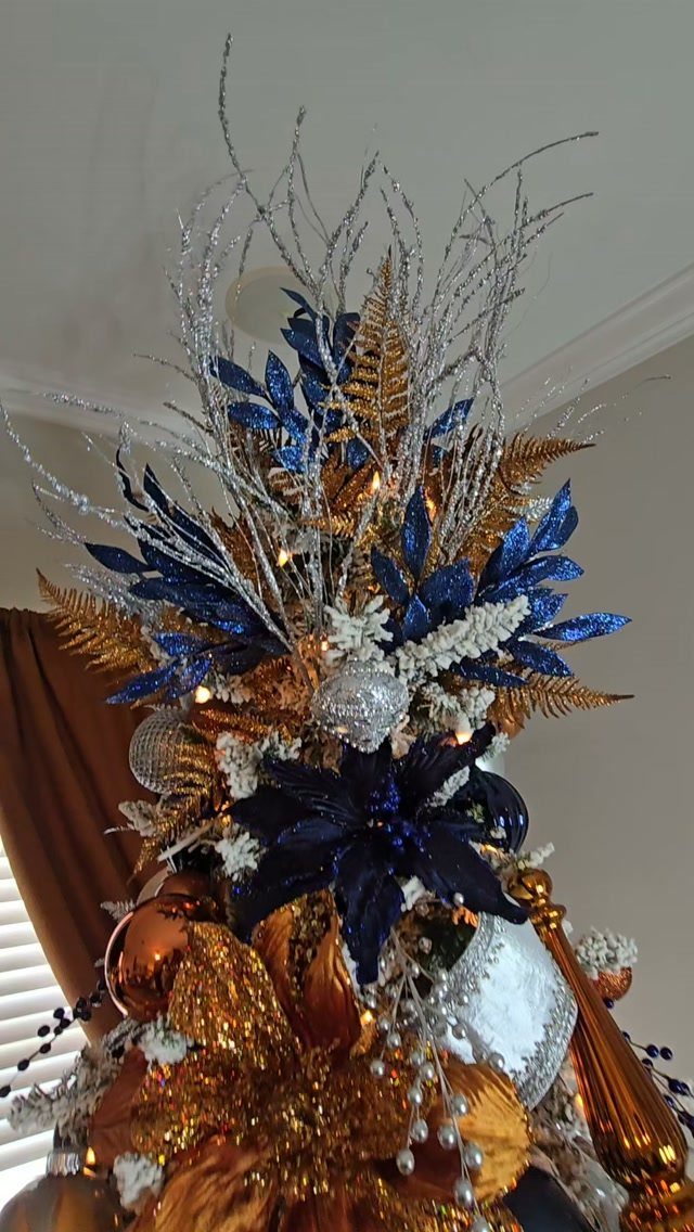 Navy blue and copper metallic holiday arrangement with silver branches and shimmering ornaments.
