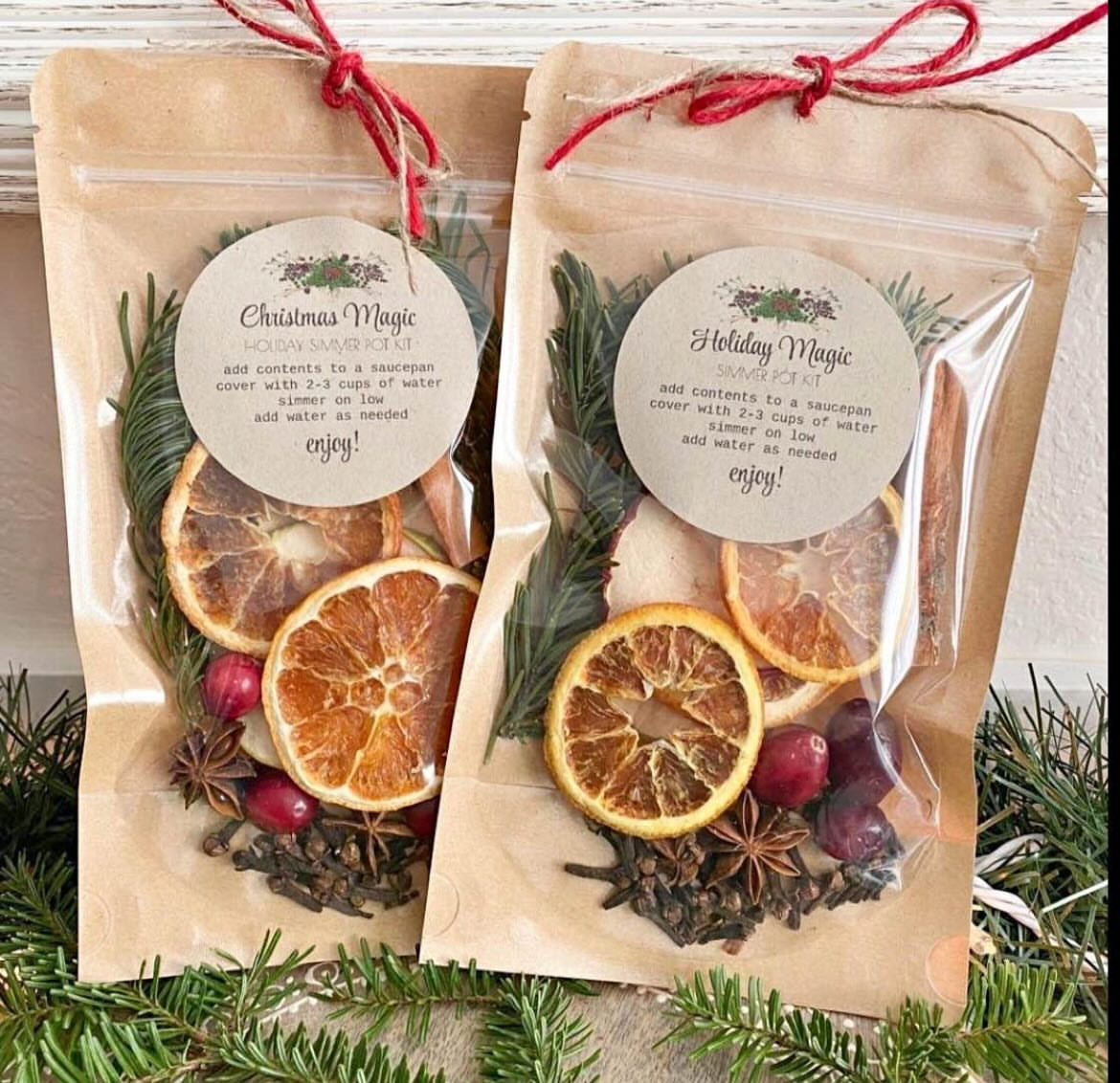 Two brown paper gift bags filled with dried citrus, spices, and berries.