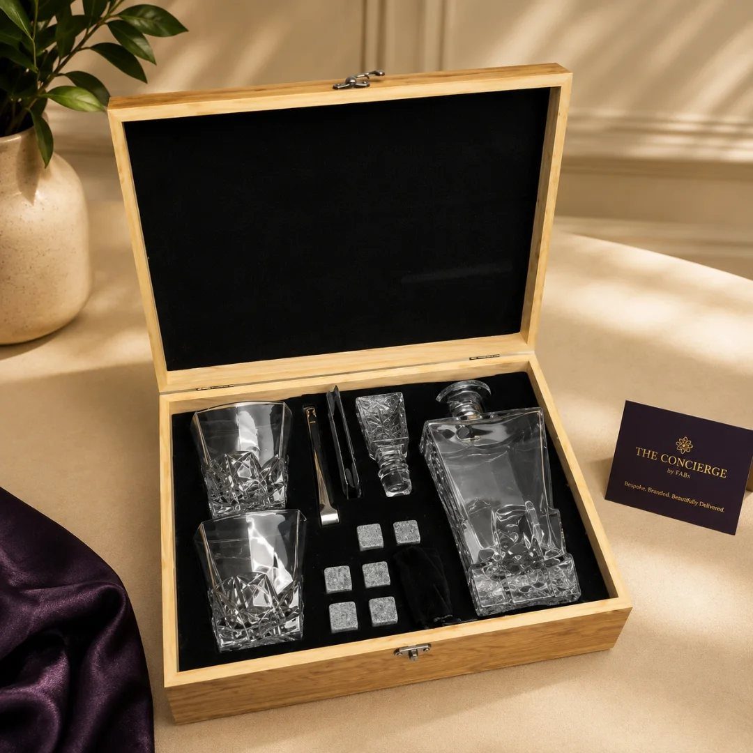 Glass decanter set with whiskey glasses and chilling stones in a wooden box.
