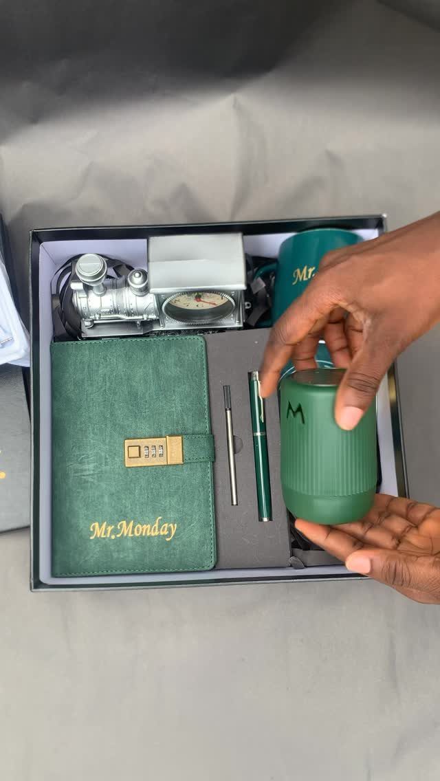Green travel mug and leather notebook gift set in a black box.