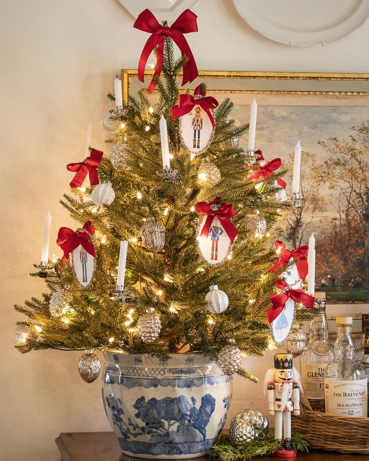 Small tabletop Christmas tree in a blue ceramic pot decorated with red bows