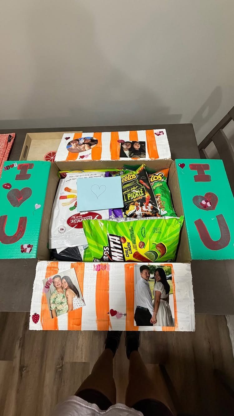 Care package box filled with snacks and decorated with couple photos and love letters.