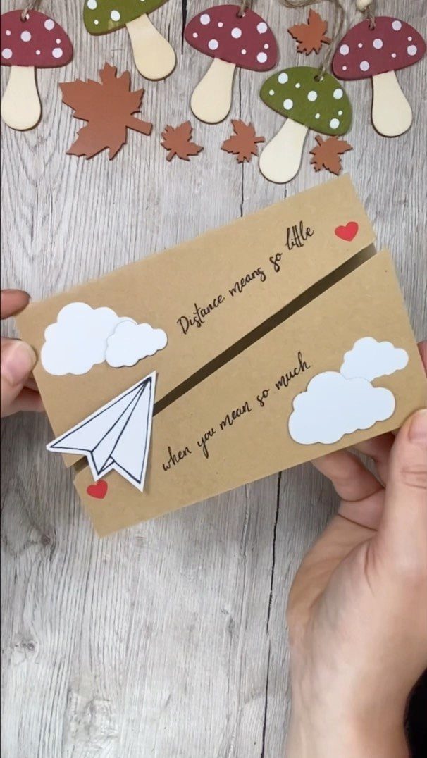 Handmade brown card with a paper airplane and clouds for long distance couples.