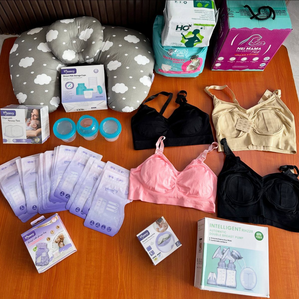 Breastfeeding starter kit with nursing pillow, bras, breast pump, and milk storage bags.
