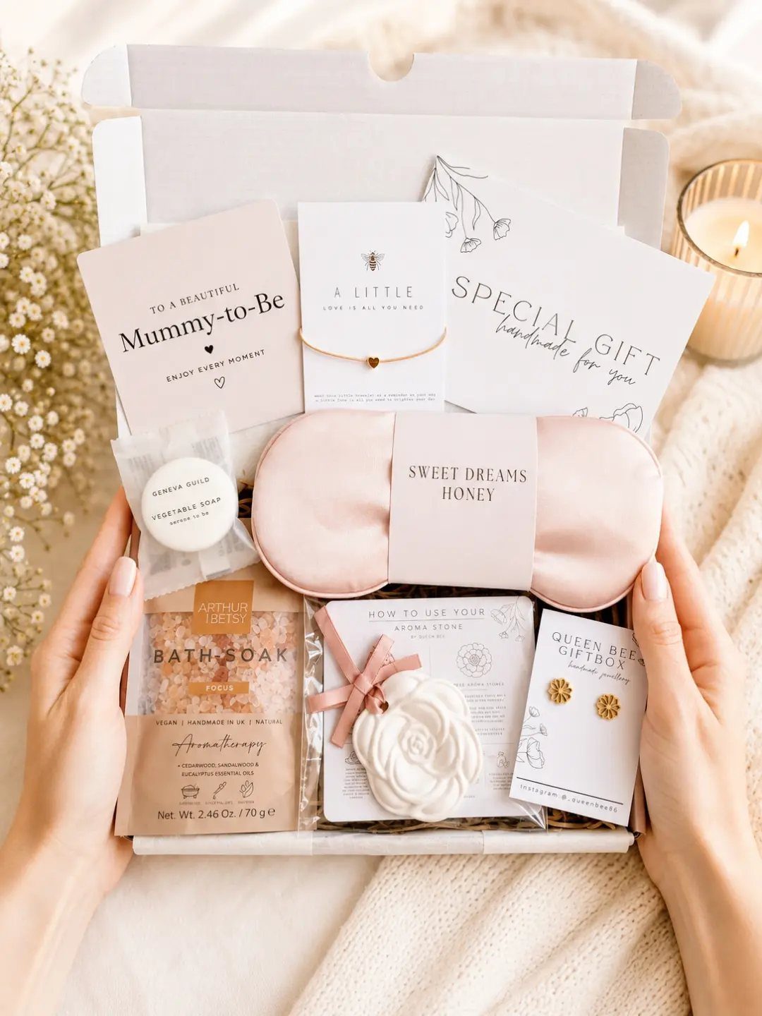 Luxury pregnancy gift box with pink eye mask, bath soak, and jewelry for mothers.