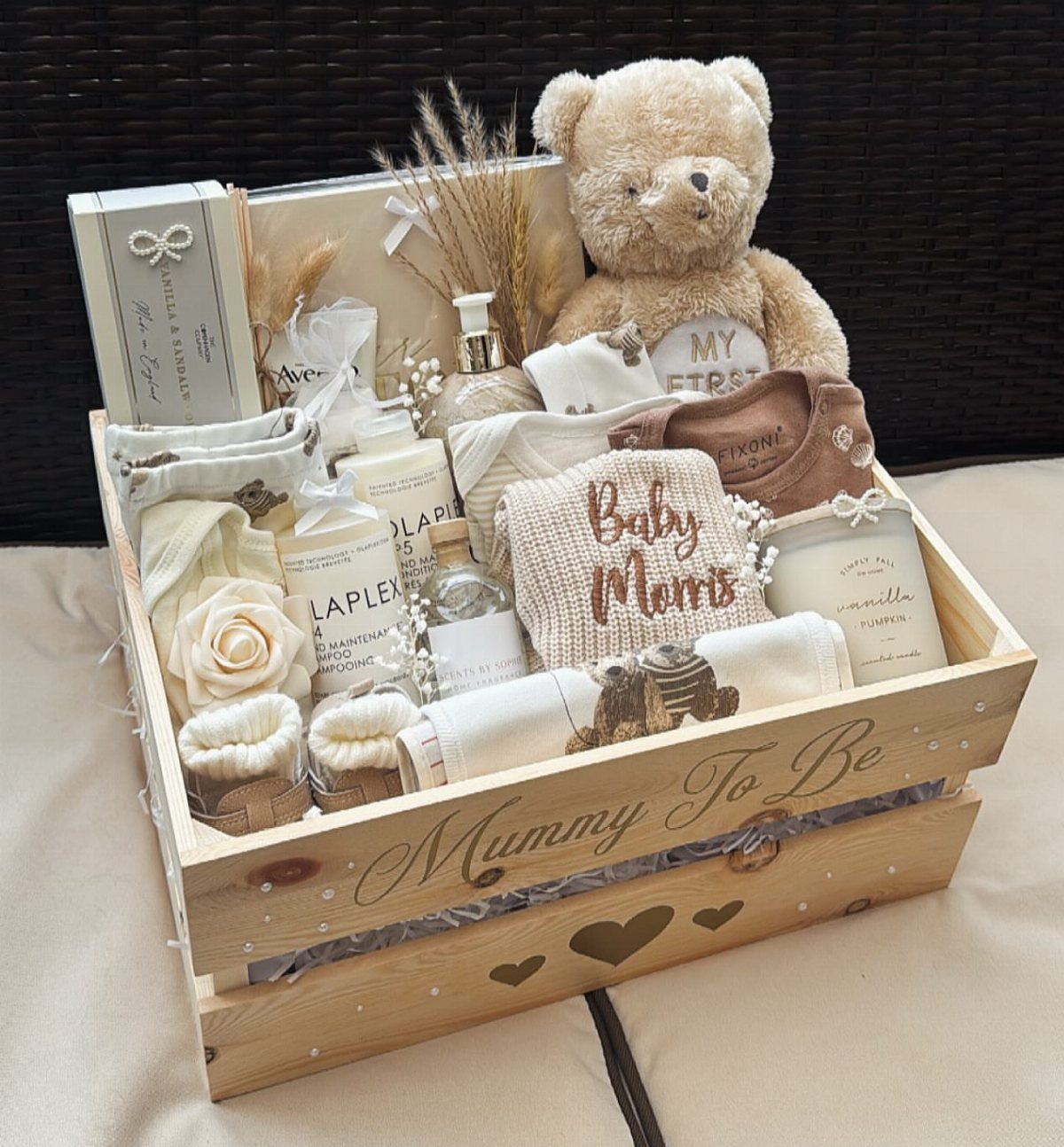 Wooden gift crate for a mother-to-be filled with baby clothes and toiletries