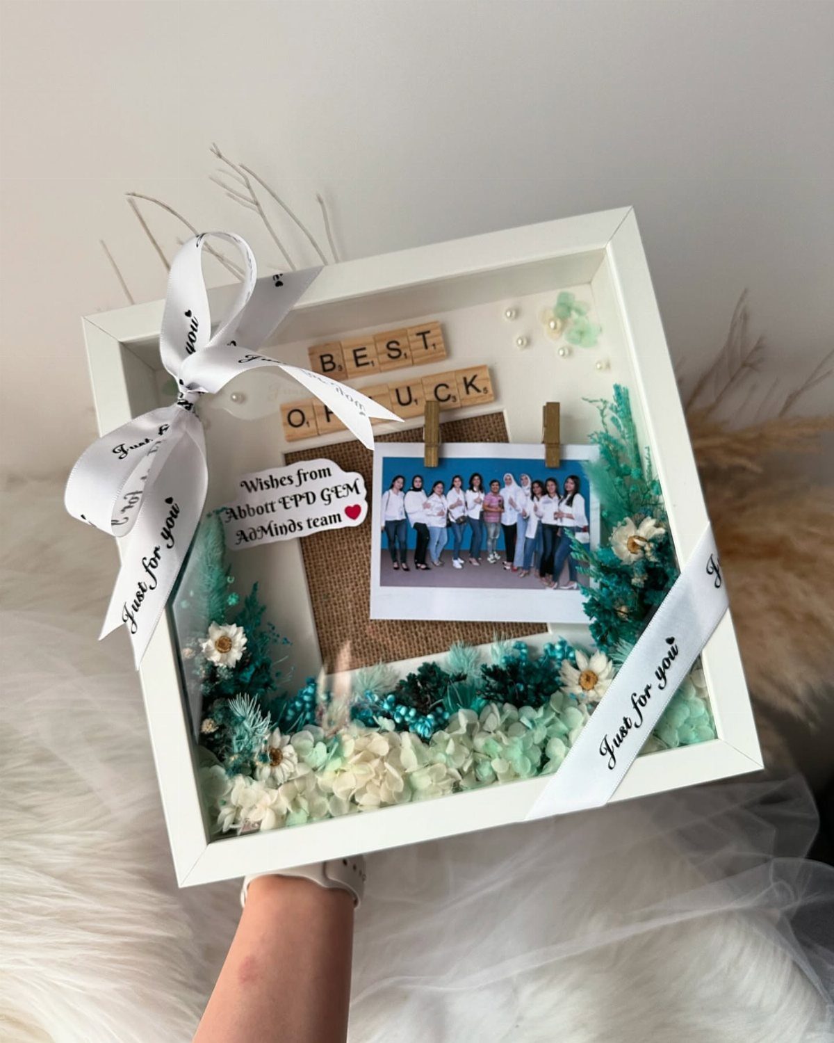 Shadow box gift with coworker photo, best of luck blocks, and teal flowers.