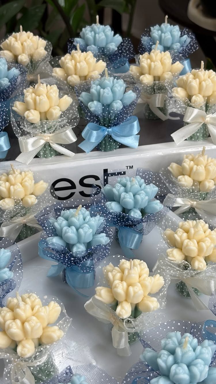 Small tulip-shaped candles in blue and cream wrapped in glittery cellophane with ribbons.