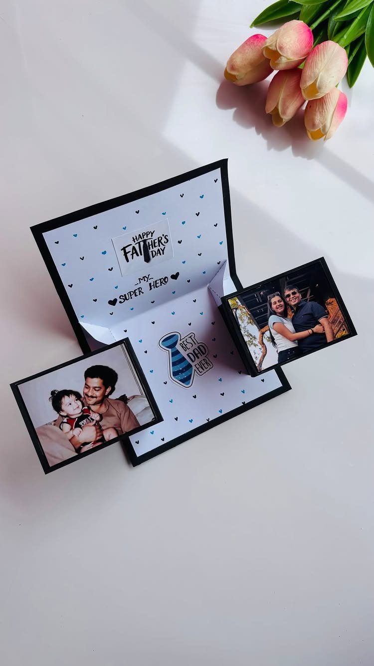 Handmade Father's Day pop-up card with family photos and pink tulips nearby.