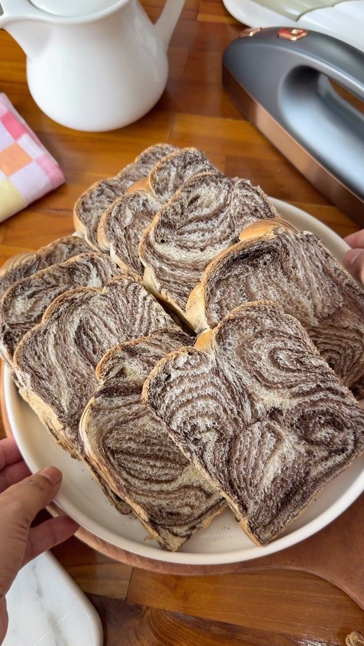 Marbled chocolate and cinnamon bread slices arranged on a white ceramic plate.