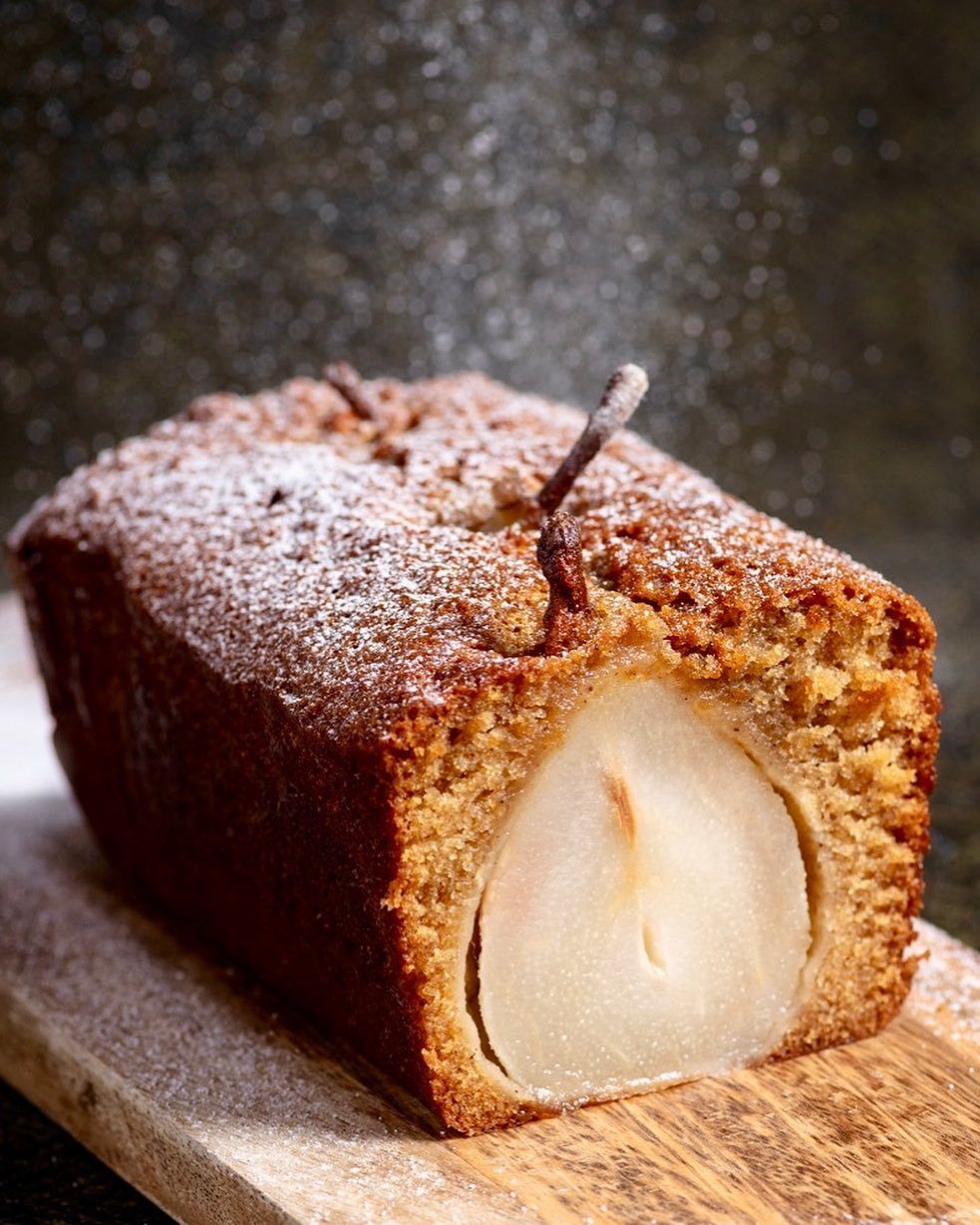 Gingerbread pear loaf cake with a whole poached pear embedded in the side.