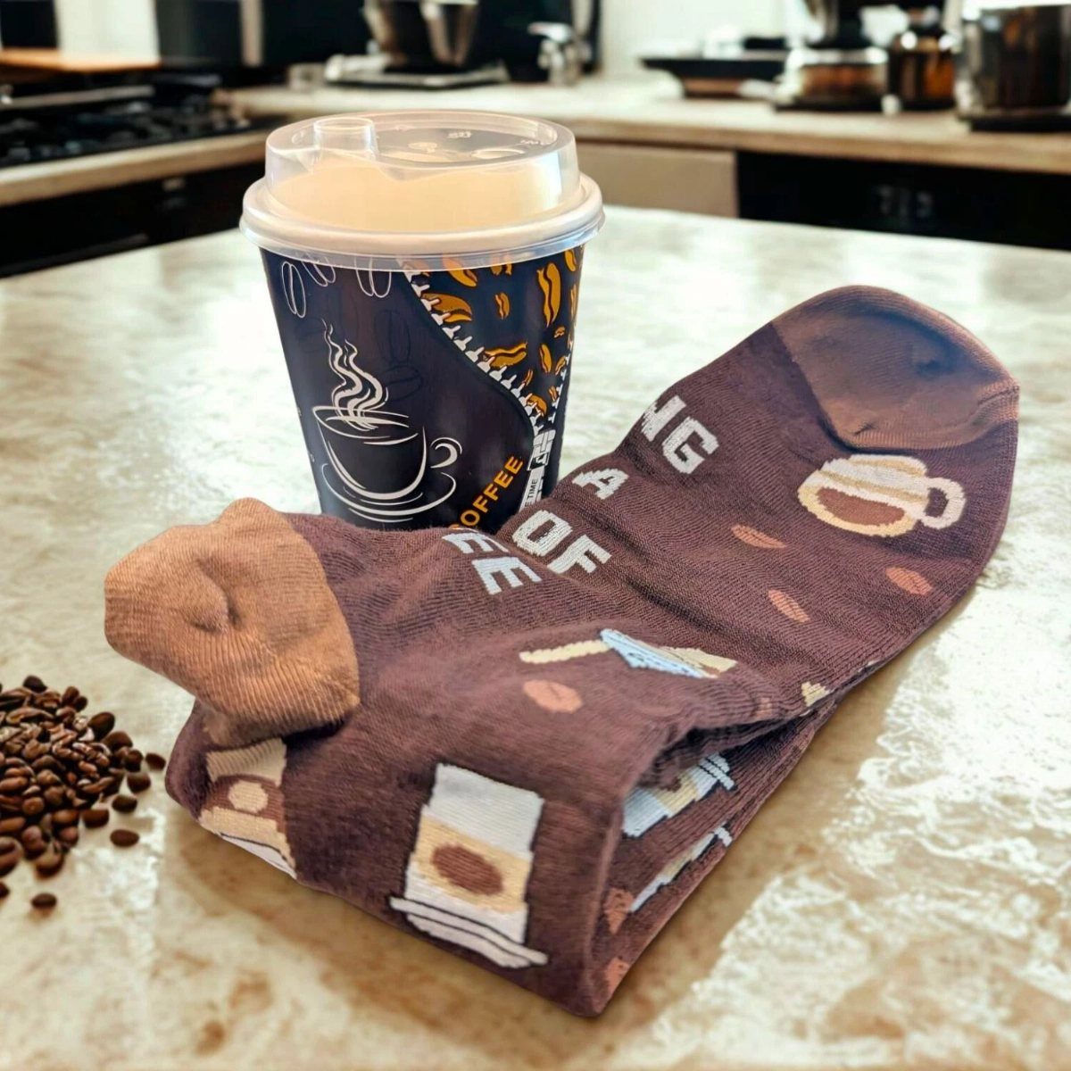 Brown coffee-themed novelty socks next to a coffee cup and scattered coffee beans.