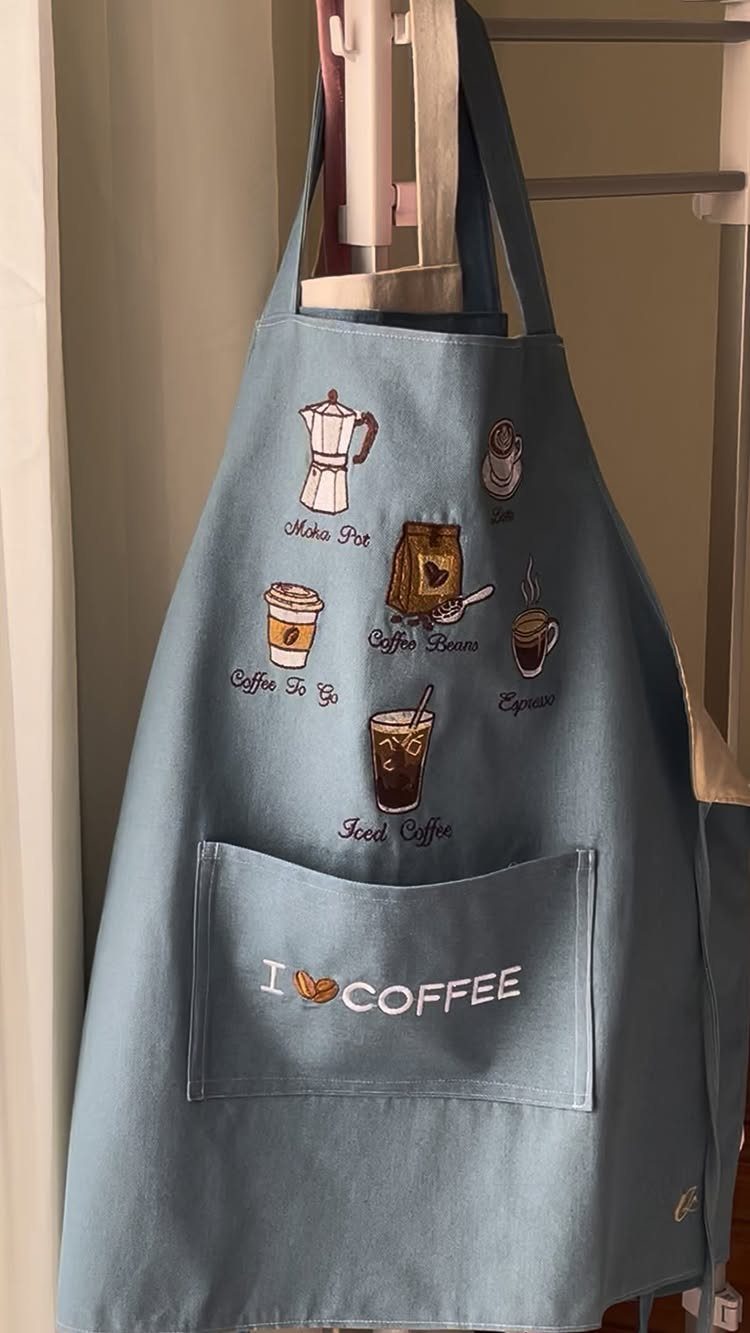 Light blue apron with coffee illustrations and I LOVE COFFEE text on pocket