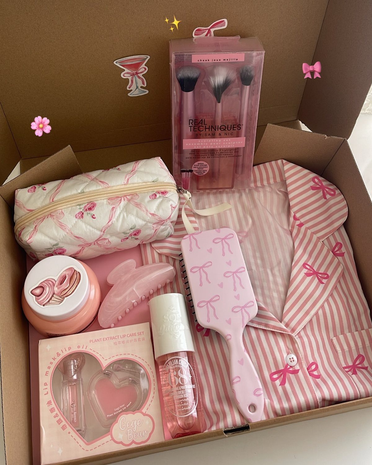 Pink themed self-care gift box with pajamas, makeup brushes, and beauty accessories.