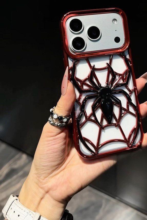 Smartphone with a red and white case featuring a large 3D black spider