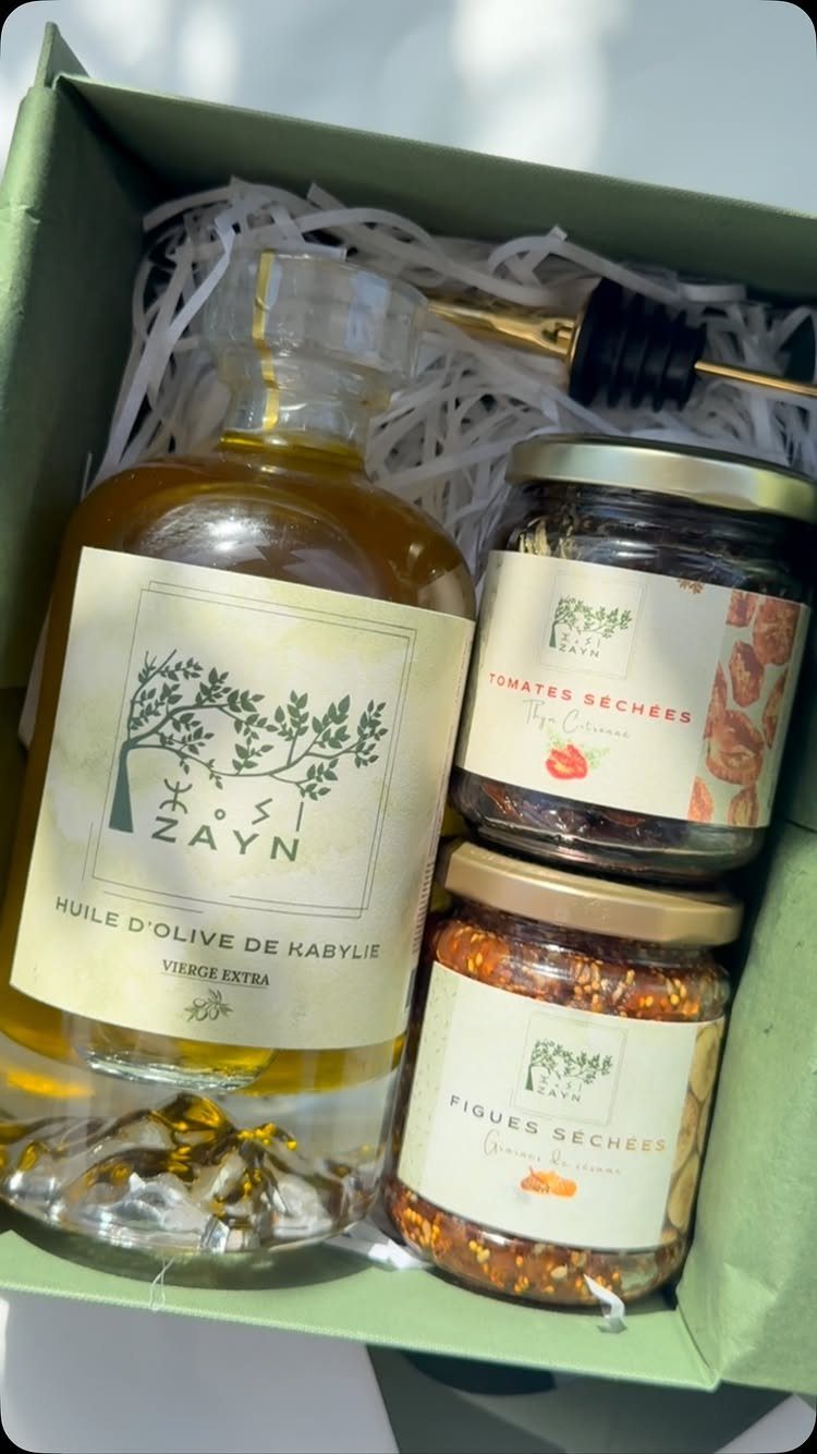 Gourmet gift box with olive oil and preserved food jars in white filler