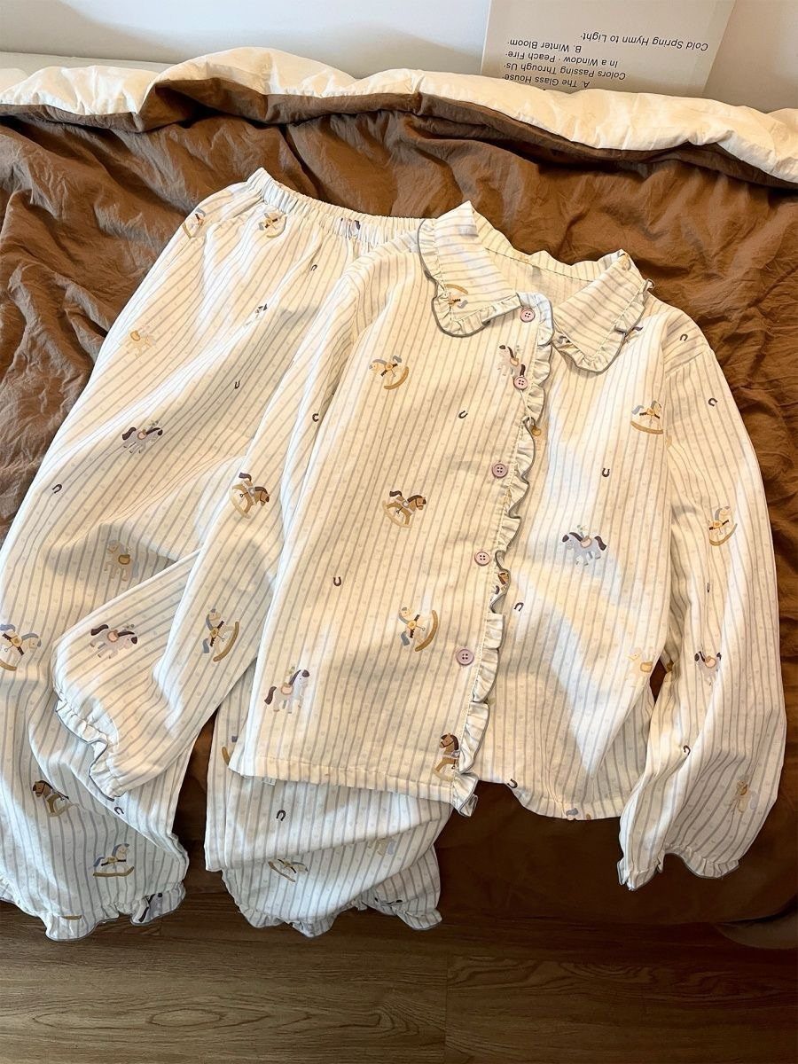 White striped pajama set with animal prints resting on a brown bedsheet.