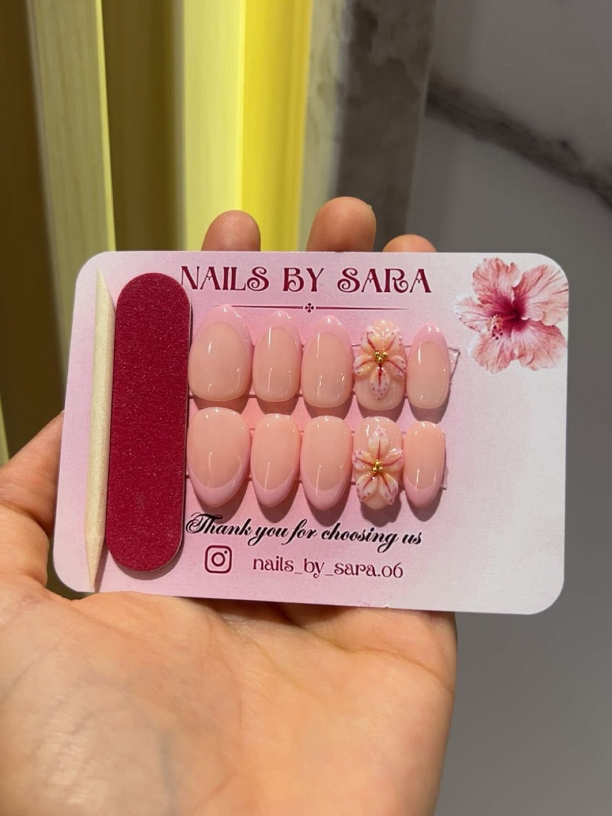 Press-on nails in light pink with 3D flowers on a pink display card.