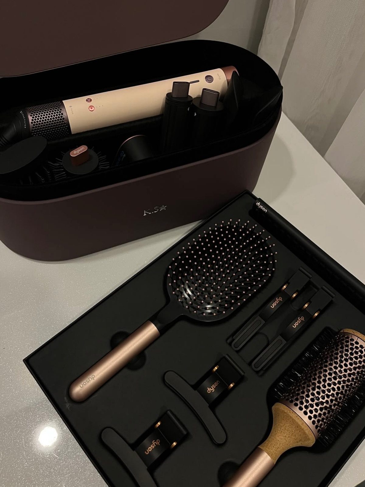 Hair styling kit with wand and attachments in a burgundy storage case