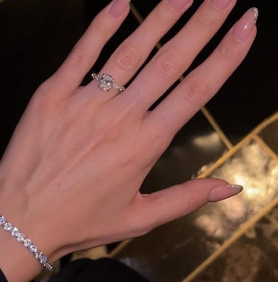 Woman's hand wearing a sparkling diamond ring and a matching tennis bracelet.