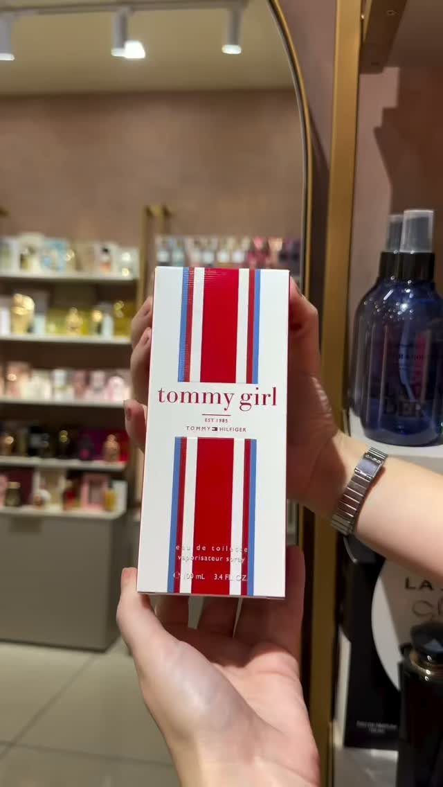 Tommy Girl perfume box with red and blue stripes held in a store