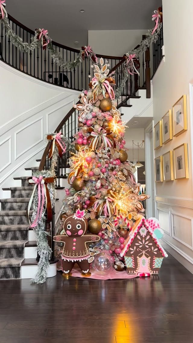 Lavishly decorated Christmas tree with oversized ornaments and bows beside a curved staircase.